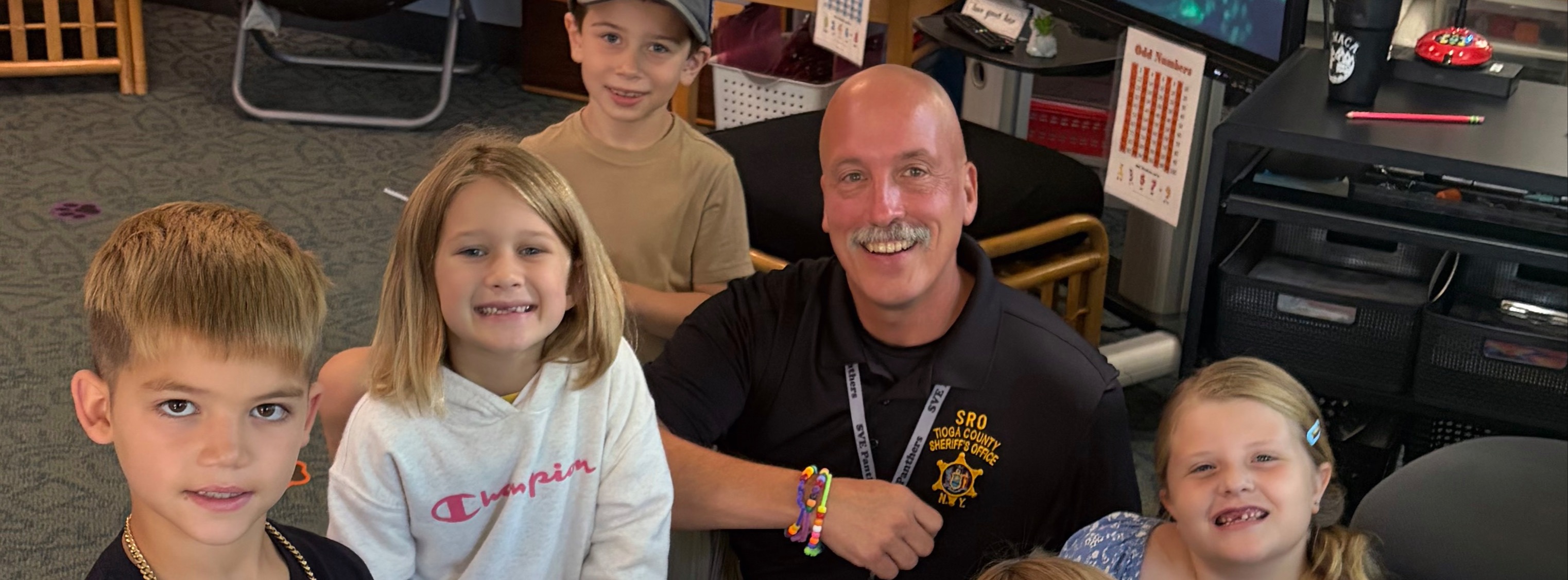 SRO making bracelets with second-graders