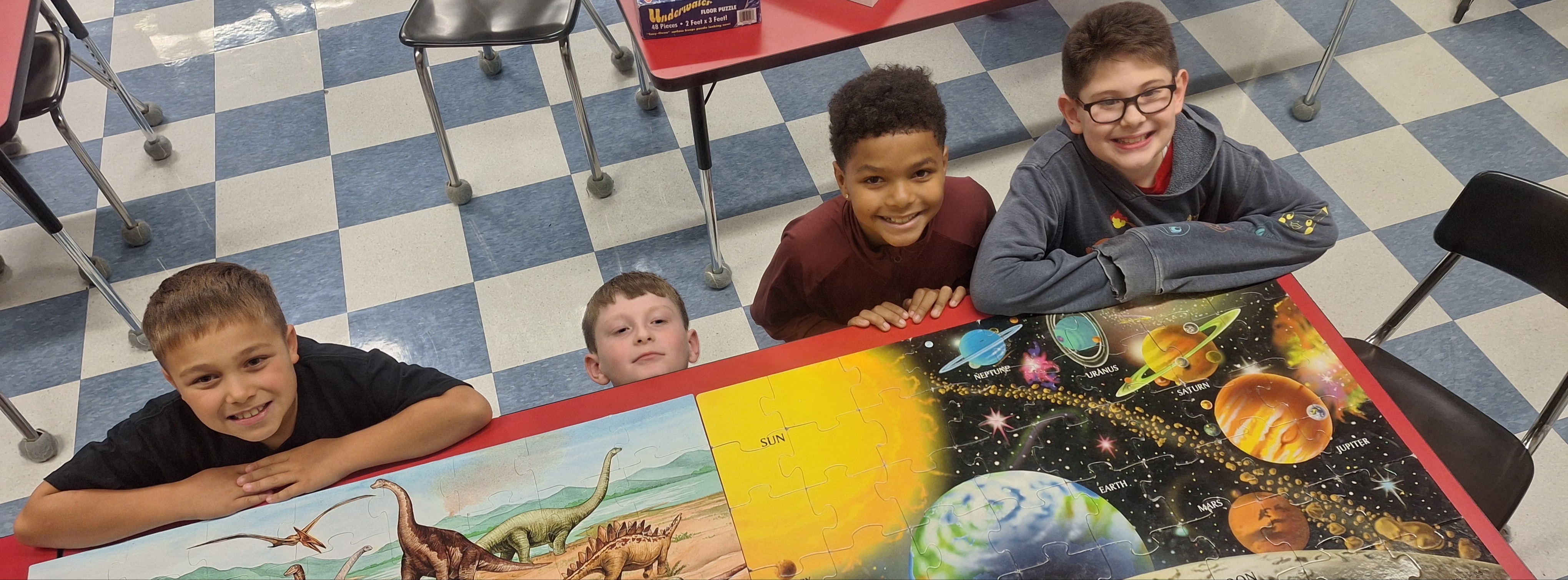boys with completed jigsaw puzzles