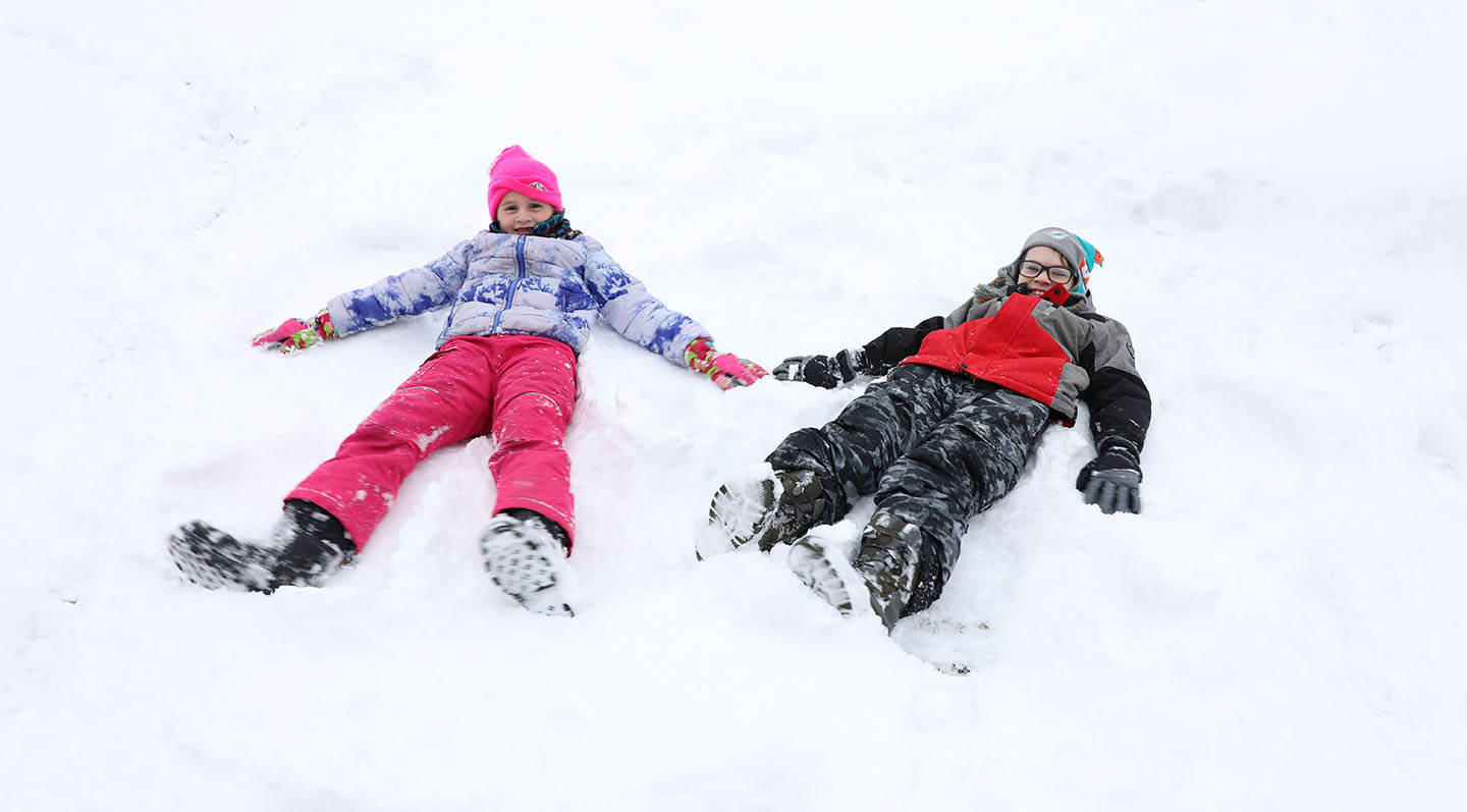 Two elementary students playing in the snow.