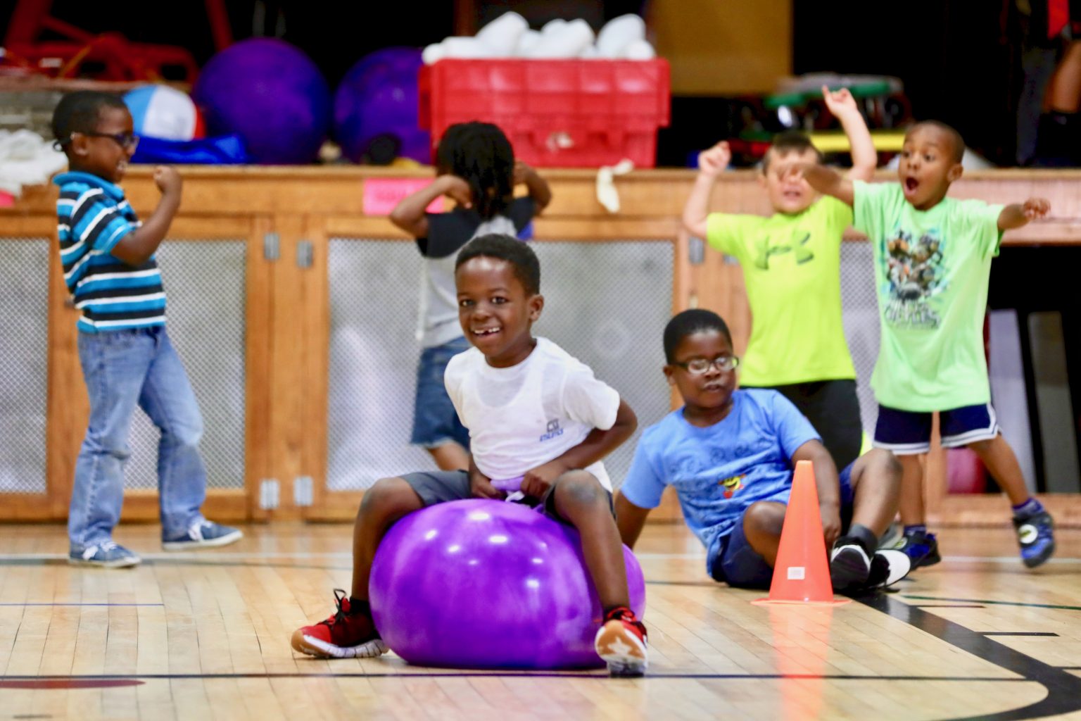 Kids running and playing with balls in PE Class