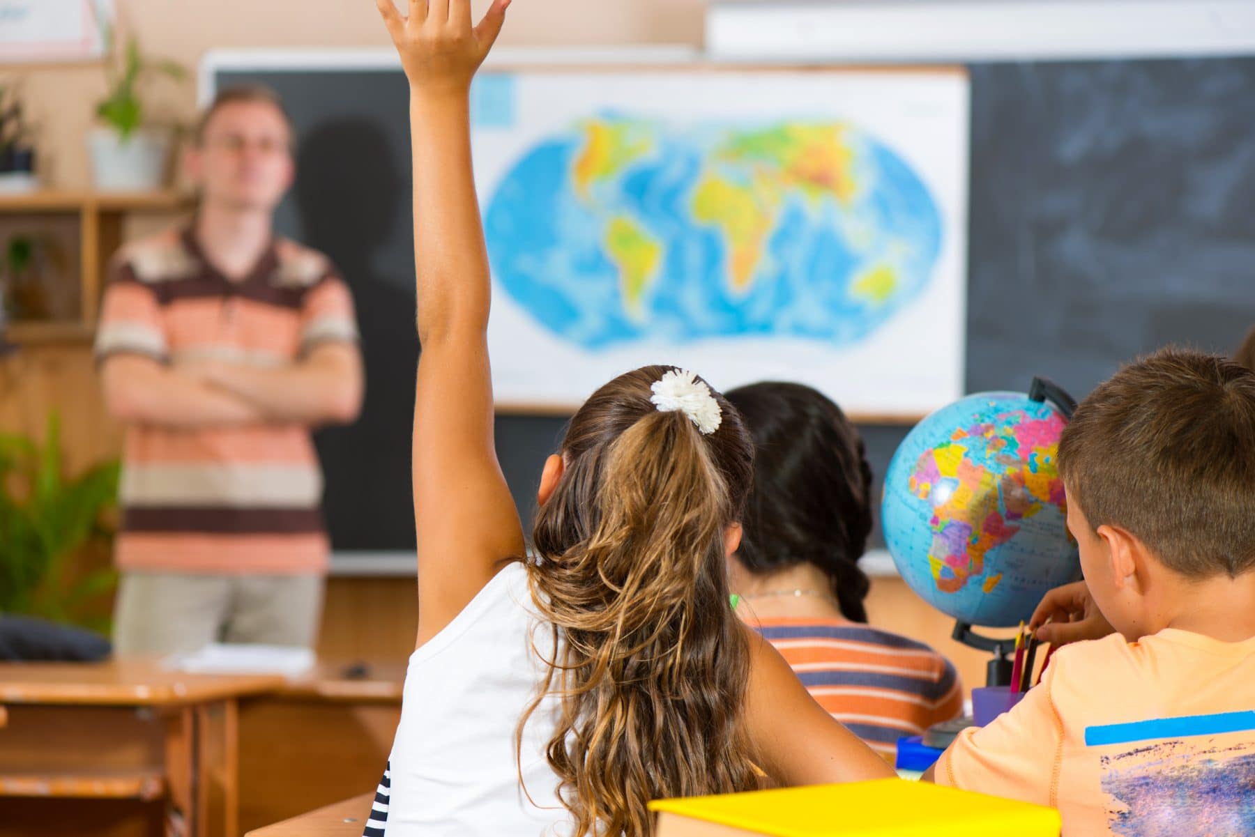 Girl raising hand in social studies class