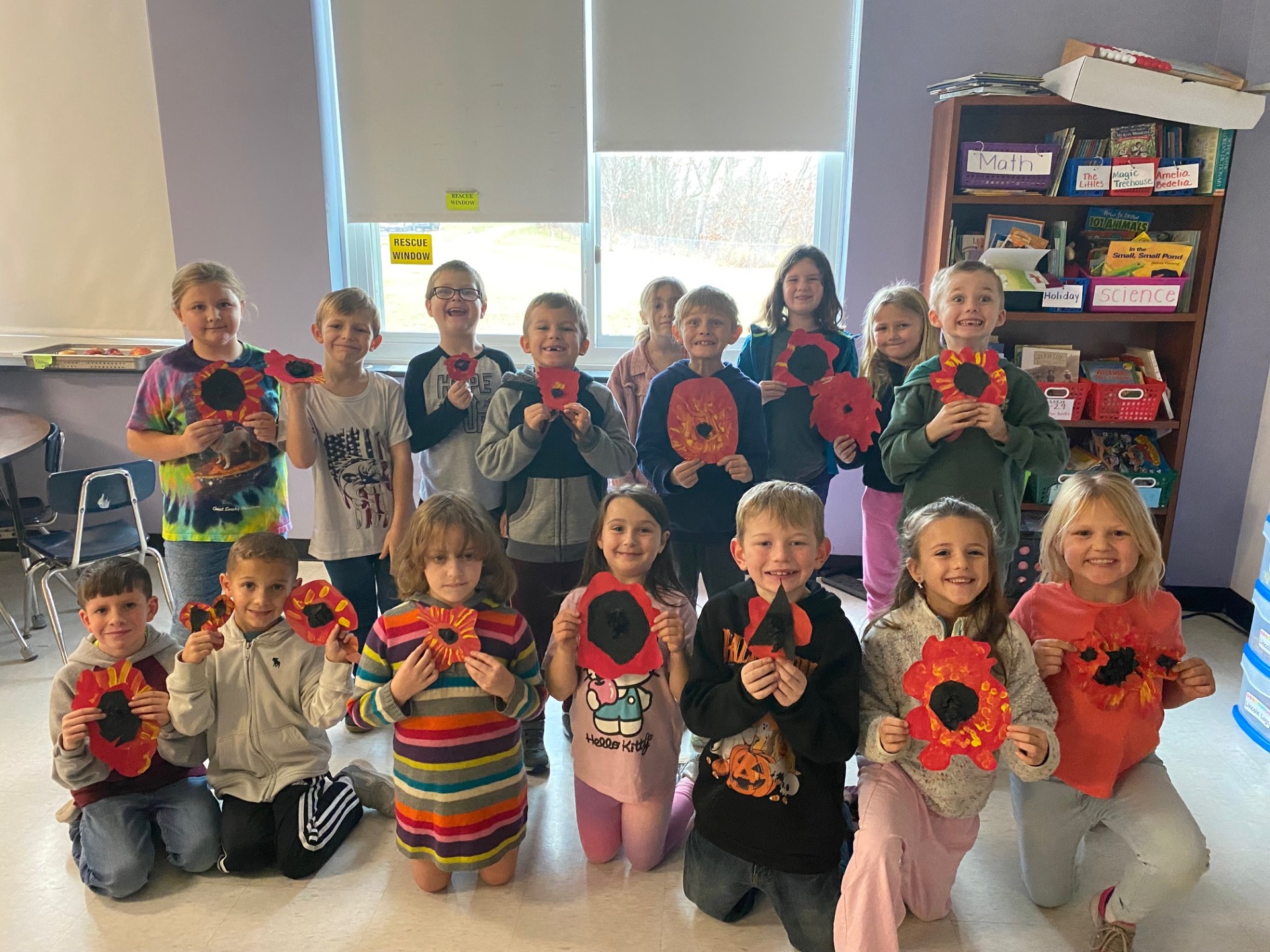 A class holds poppies they painted