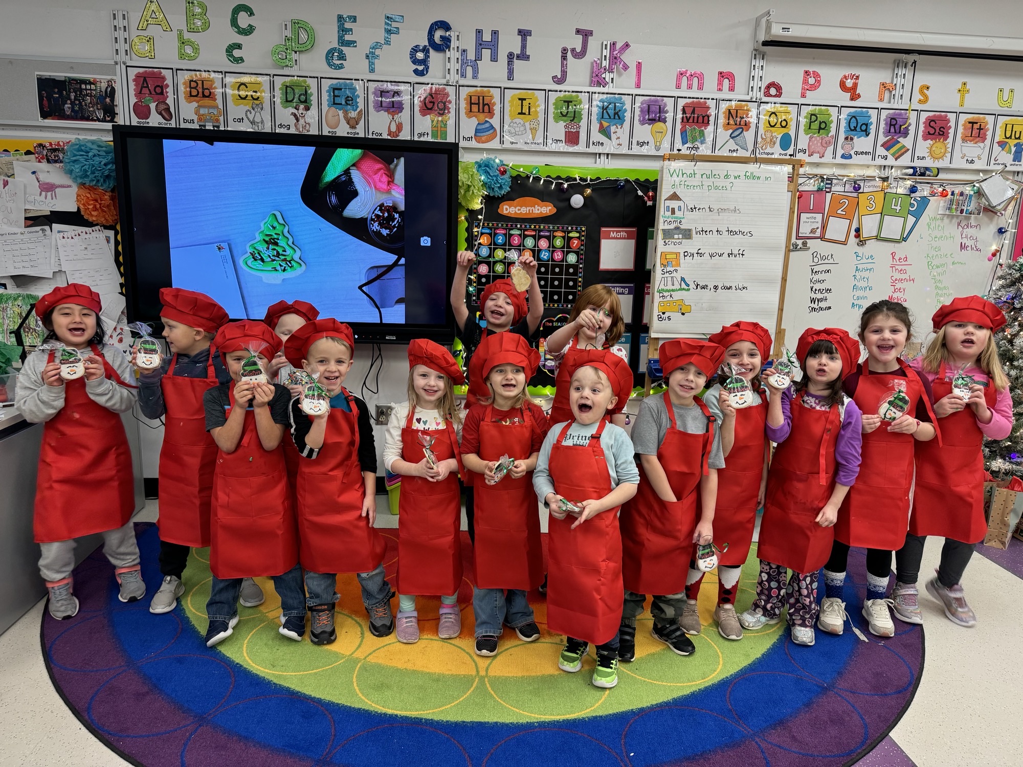 A kindergarten class stands in their cookie decorating outfits