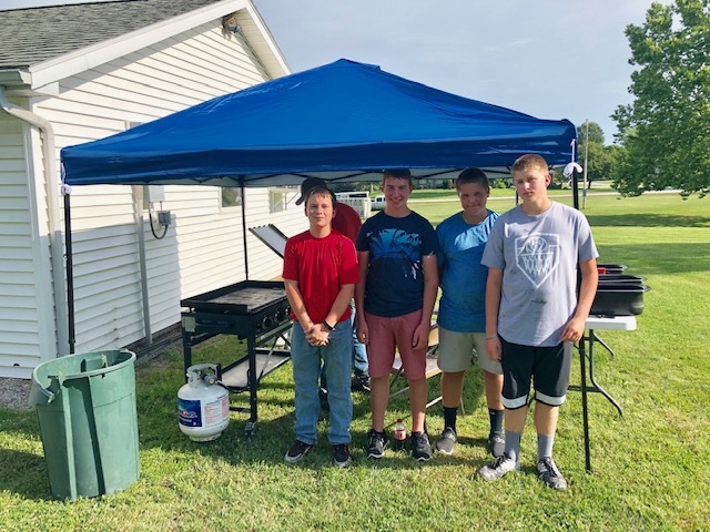 4 FFA members in front of a tent