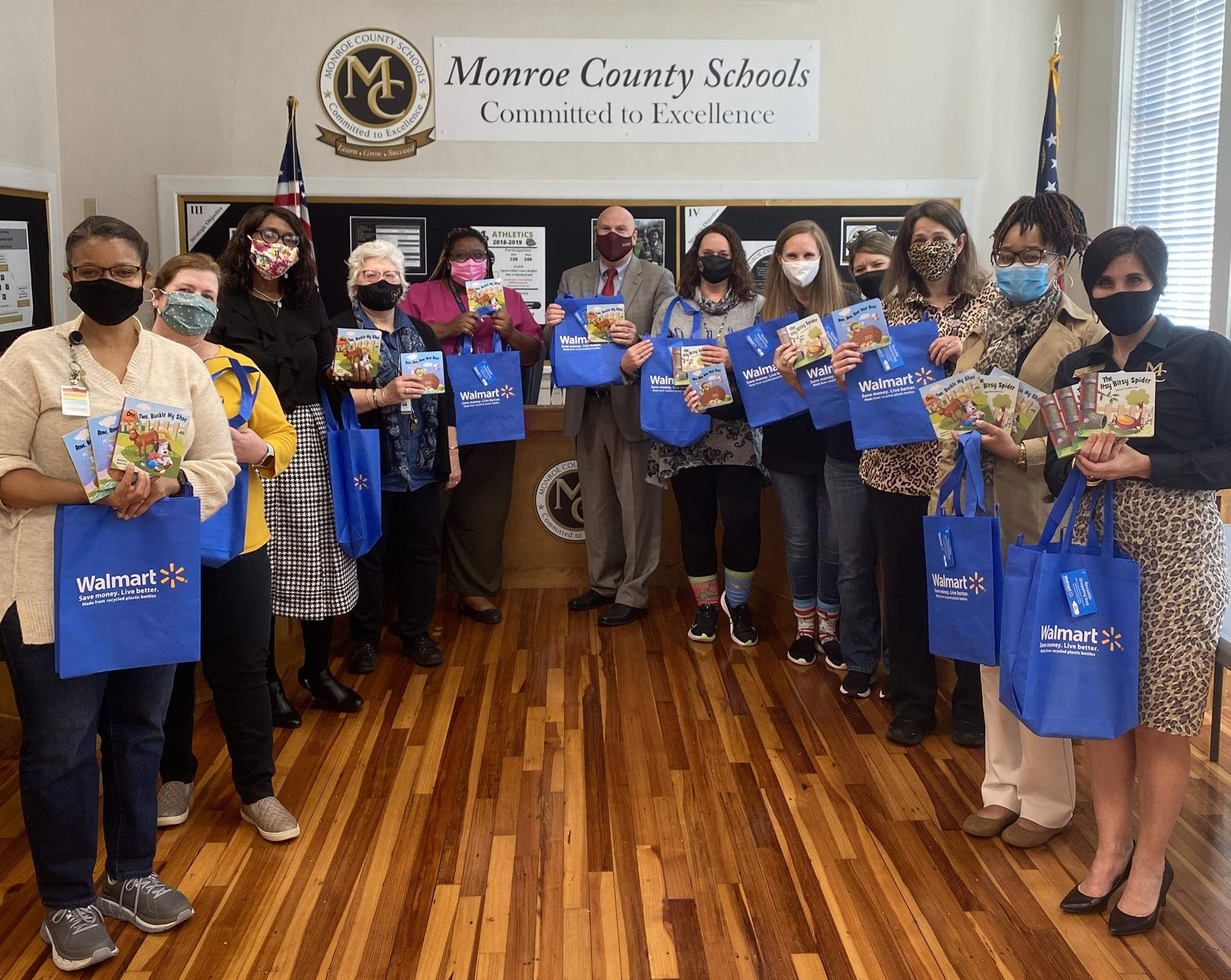 monroe county literary council holding blue walmart totes