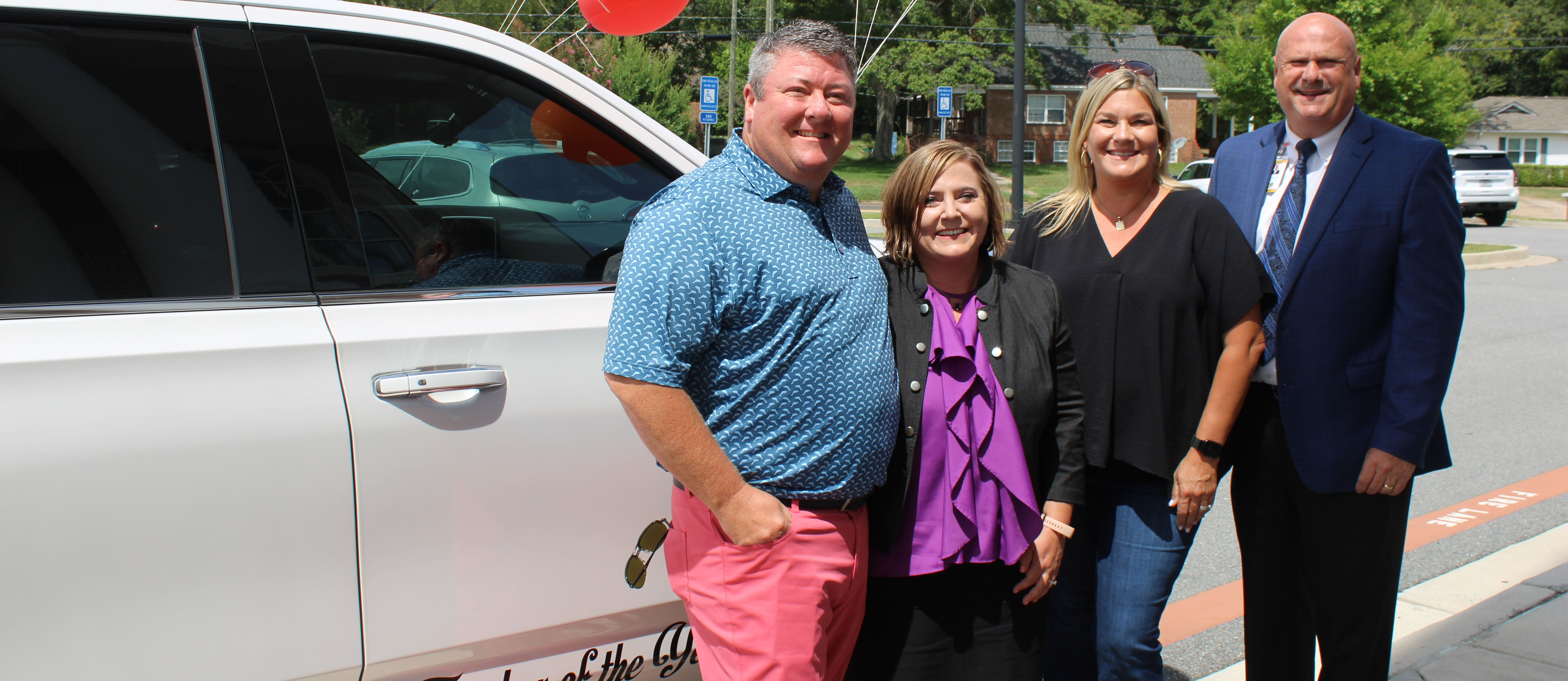 Monroe County Teacher of the Year Amanda Holloway posing in front of her new Chevy Tahoe with Supt. Mike Hickman and the owners of Volume Chevrolet