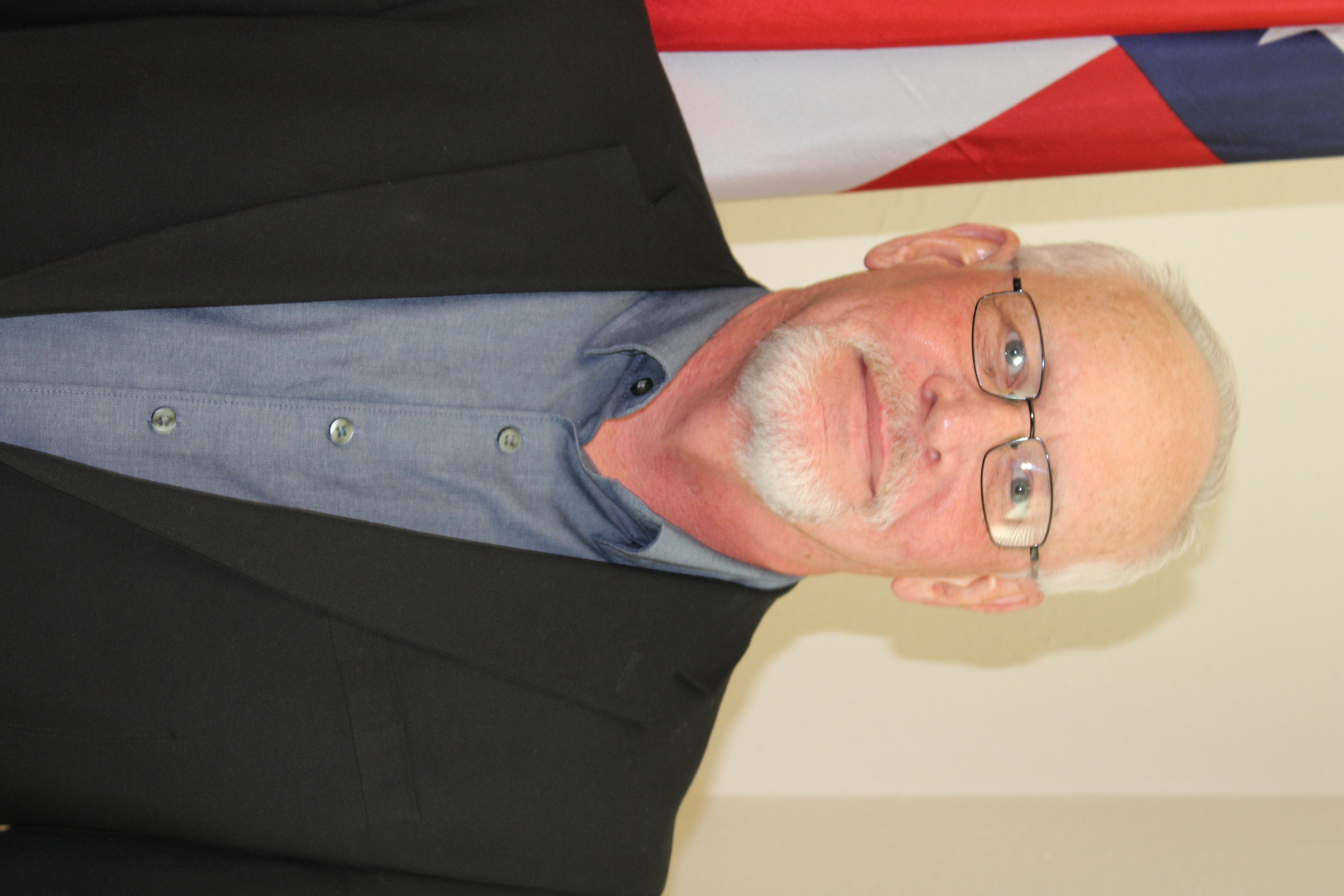 Robert Jenkins standing next to a flag