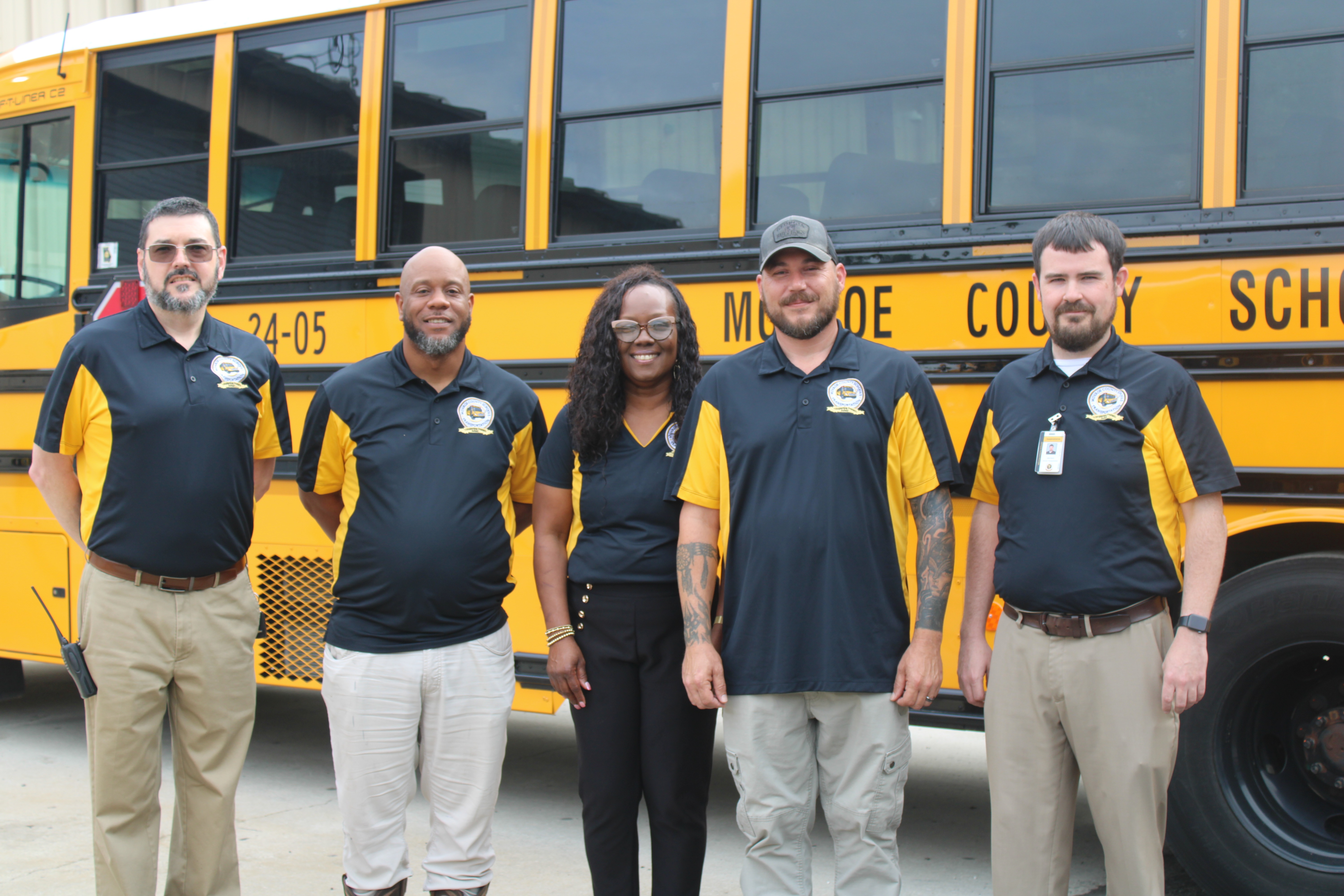Transportation staff in front of a bus