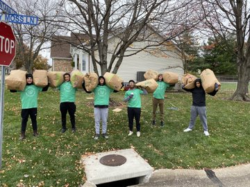Students holding lawn and leaf bags