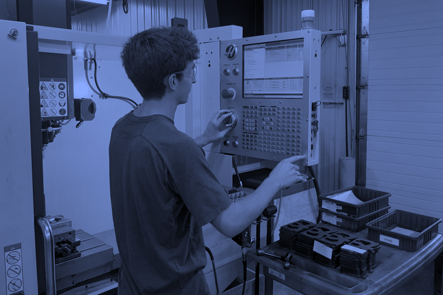 Student runs CNC machine in metals shop
