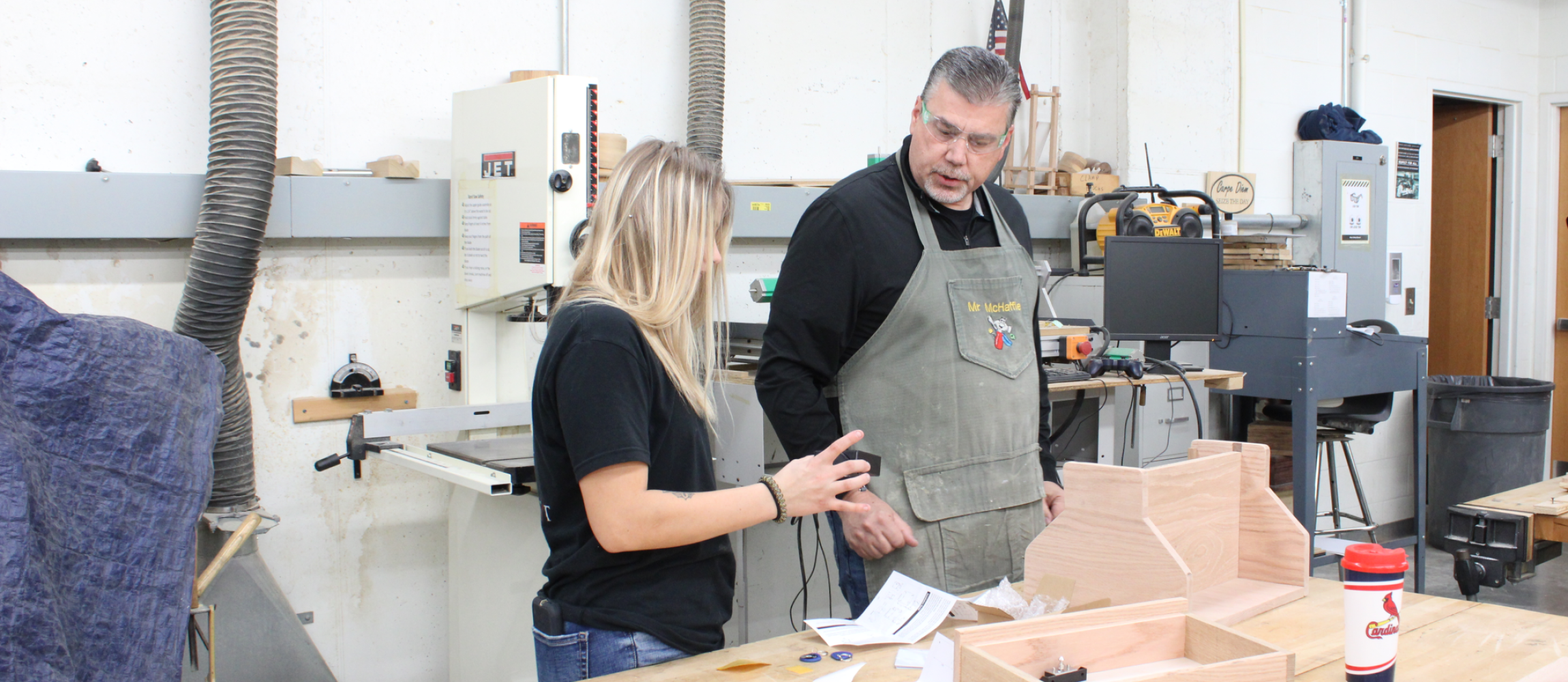 A student talking to Mr. McHaffie about their wood working project.