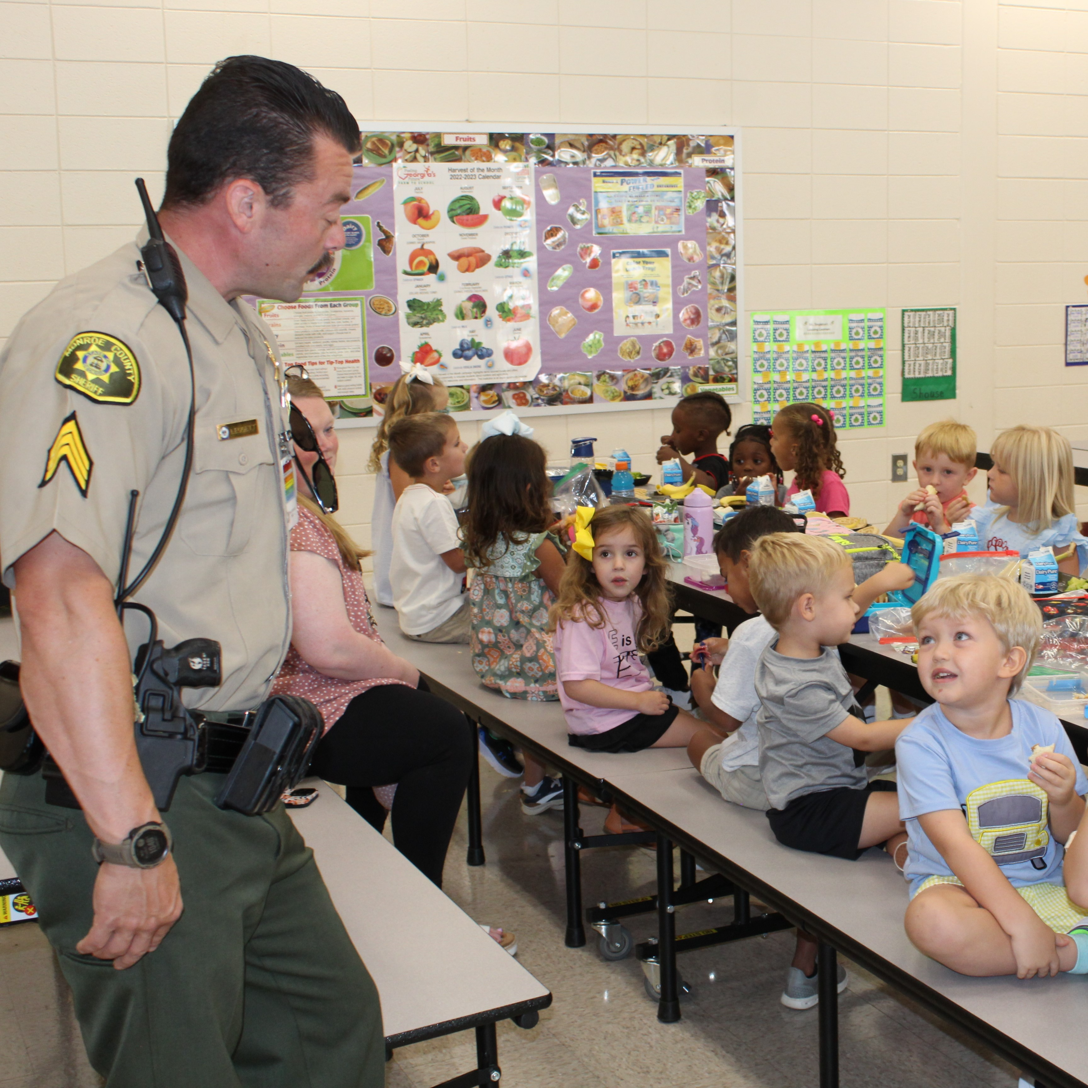 students listening to school resource officer while eating lunch