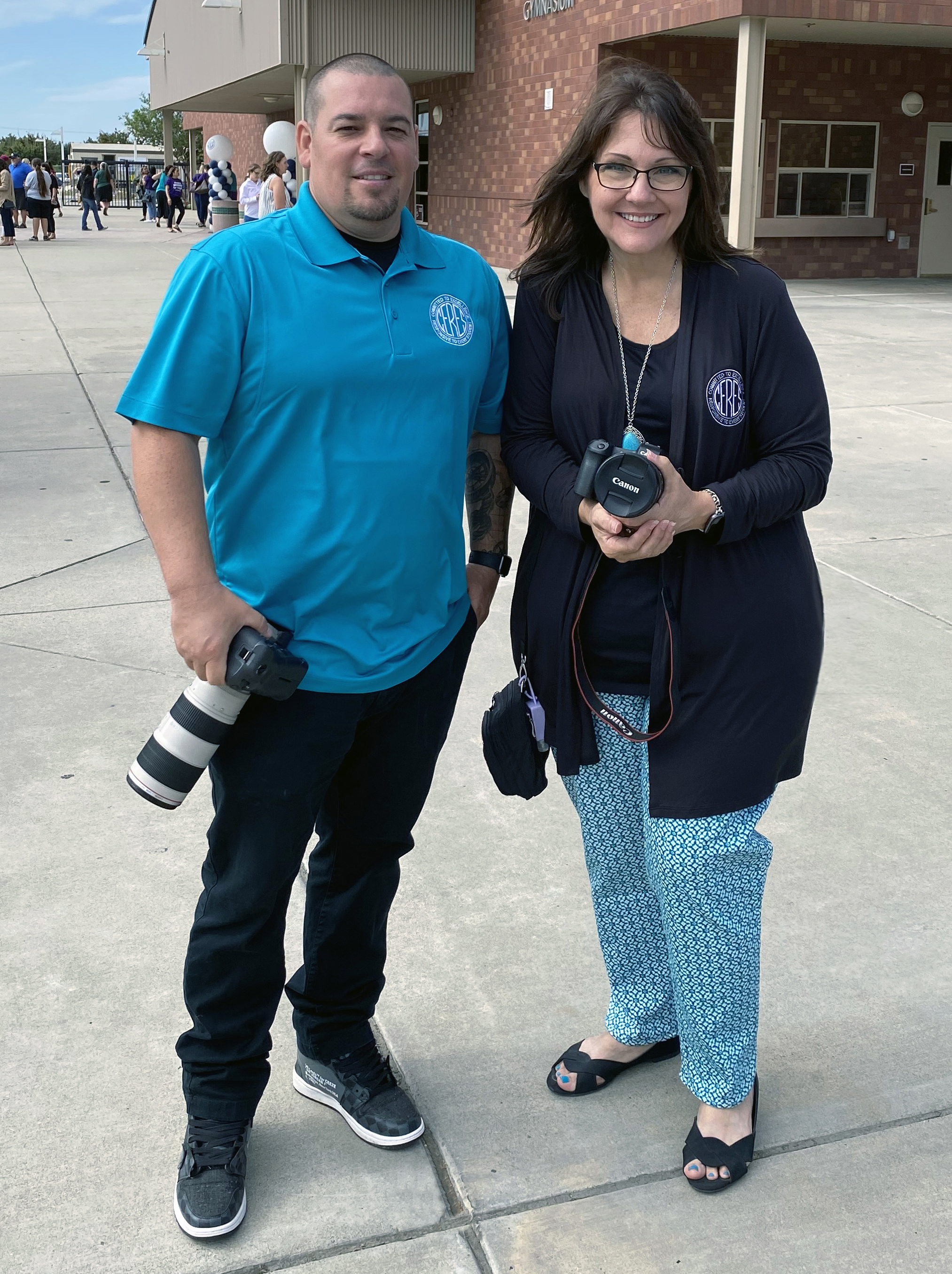 Sal Chavez and Beth Jimenez hold cameras in front of CVHS Gym