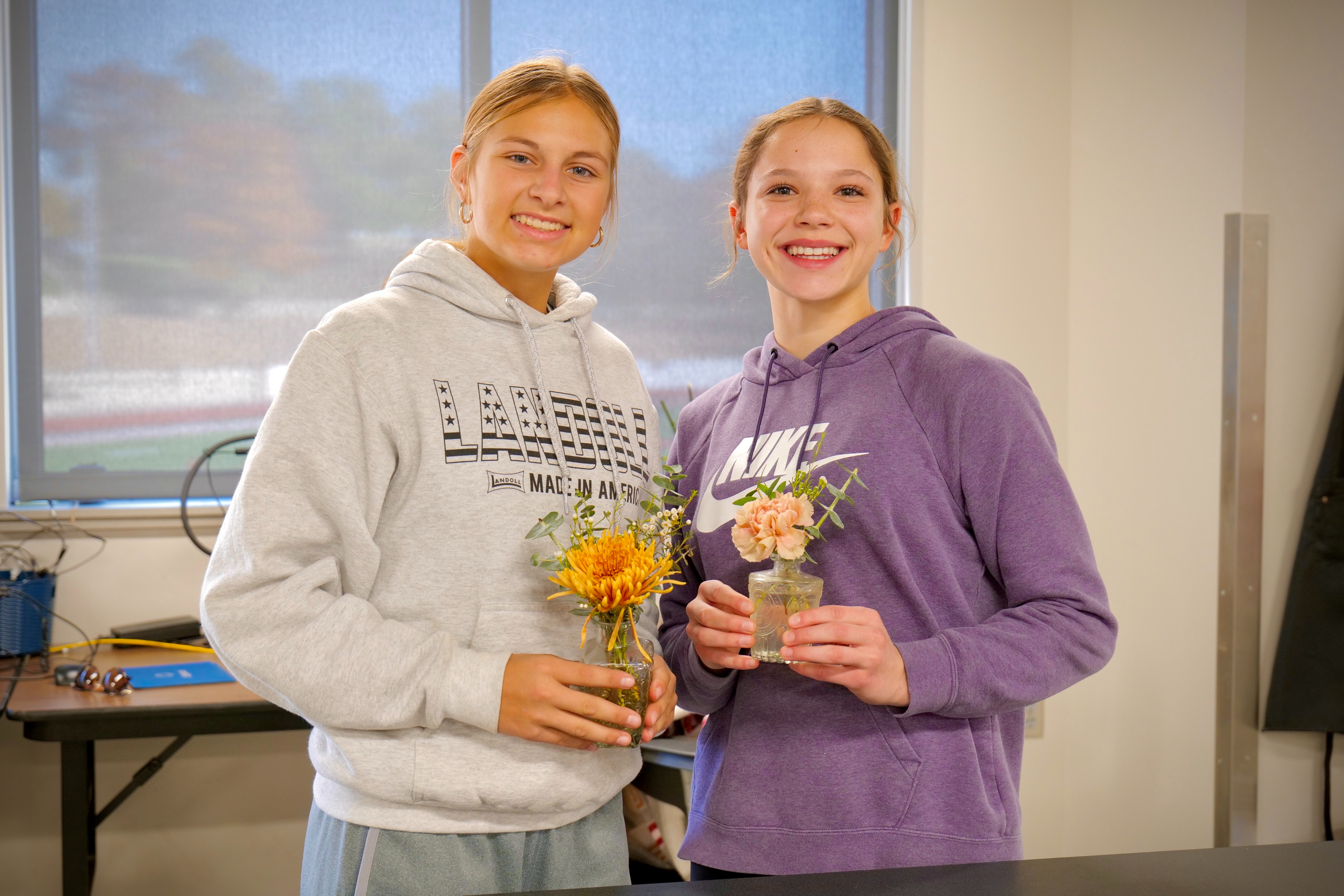 Students plant flowers in front of building