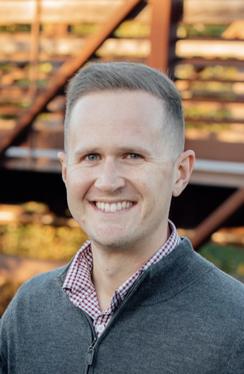 Headshot of Mr. Allmon wearing a gray sweater outdoors