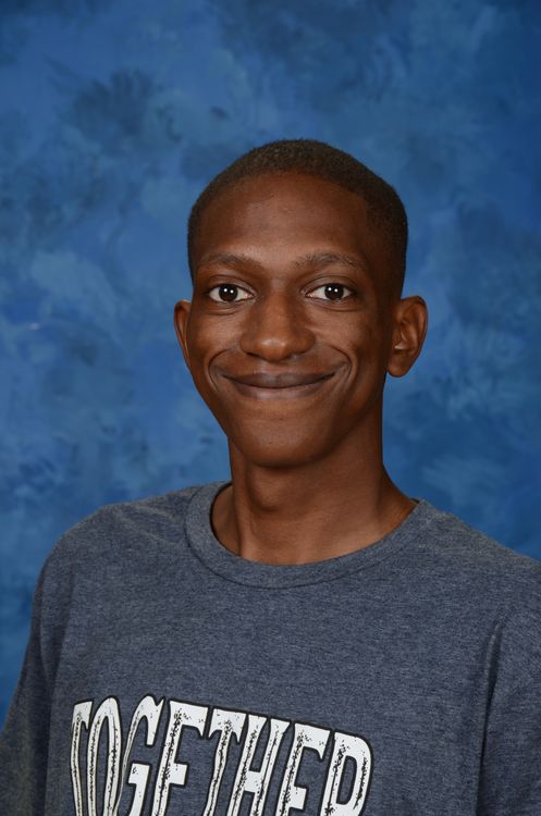 Picture of Devon Wilbert with dark gray shirt and blue background