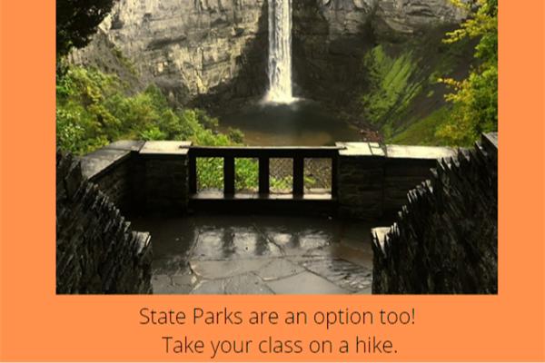 Photo of stone patio with a railing facing a narrow waterfall at Taughcanok State Park. 