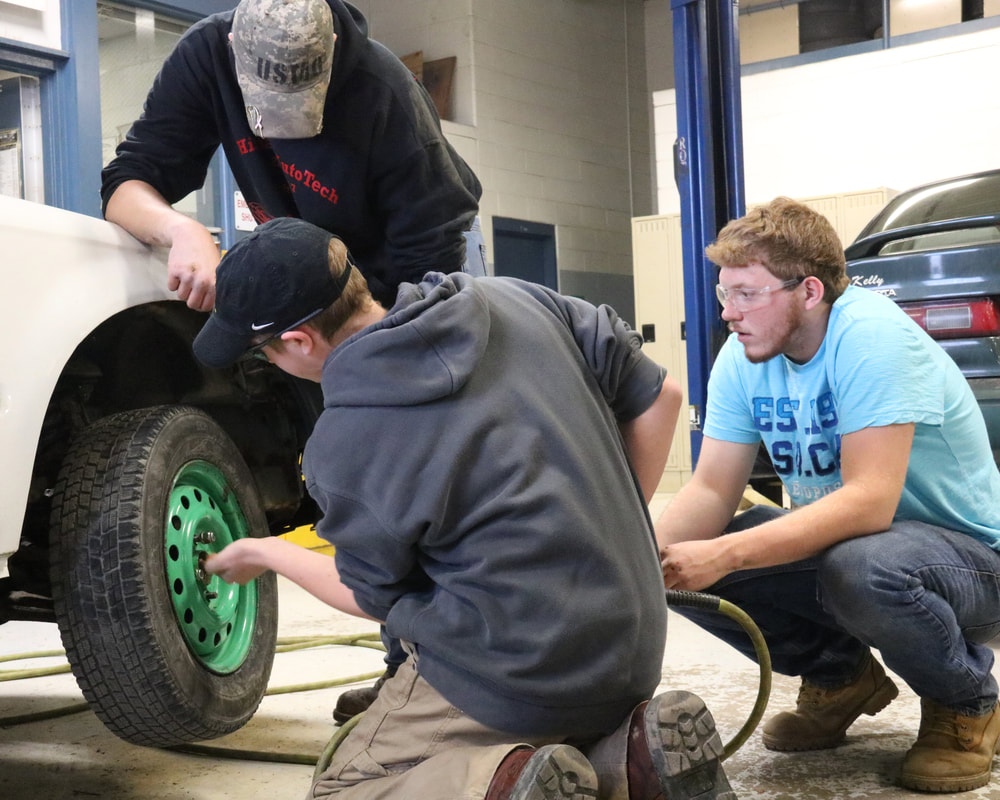 auto tech students changing tire