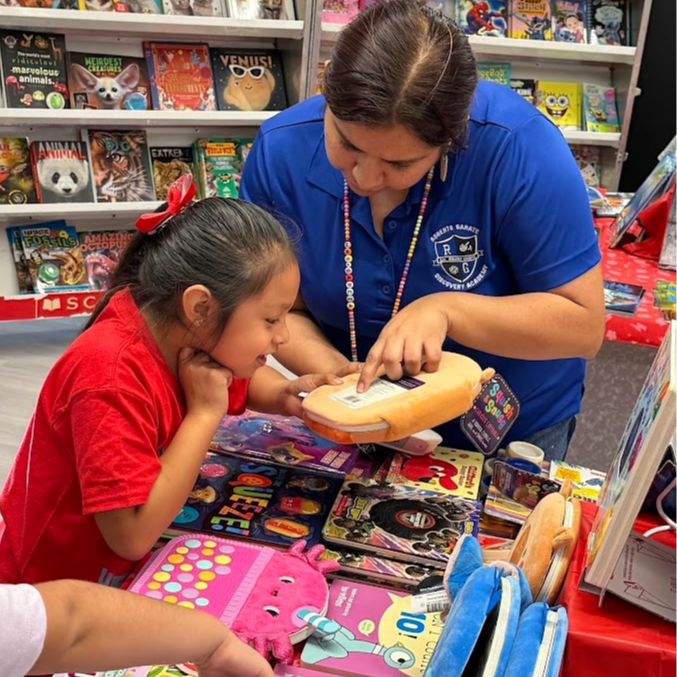 a teacher showing the student how to view the price of a book at the book fair