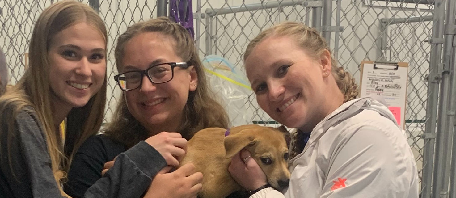 High School students holding puppy