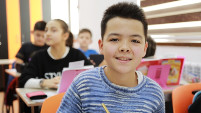 Student in the classroom smiling for the camera