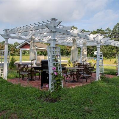 A pergola with a sitting area underneath