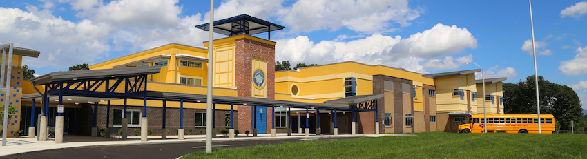 Front of the school building on a mostly sunny day