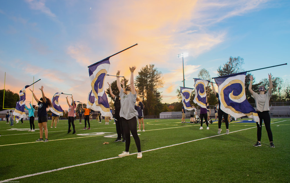 Flag team doing a routine on the football field at dusk