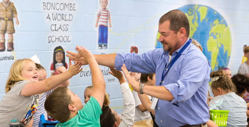 Students high fiving a teacher