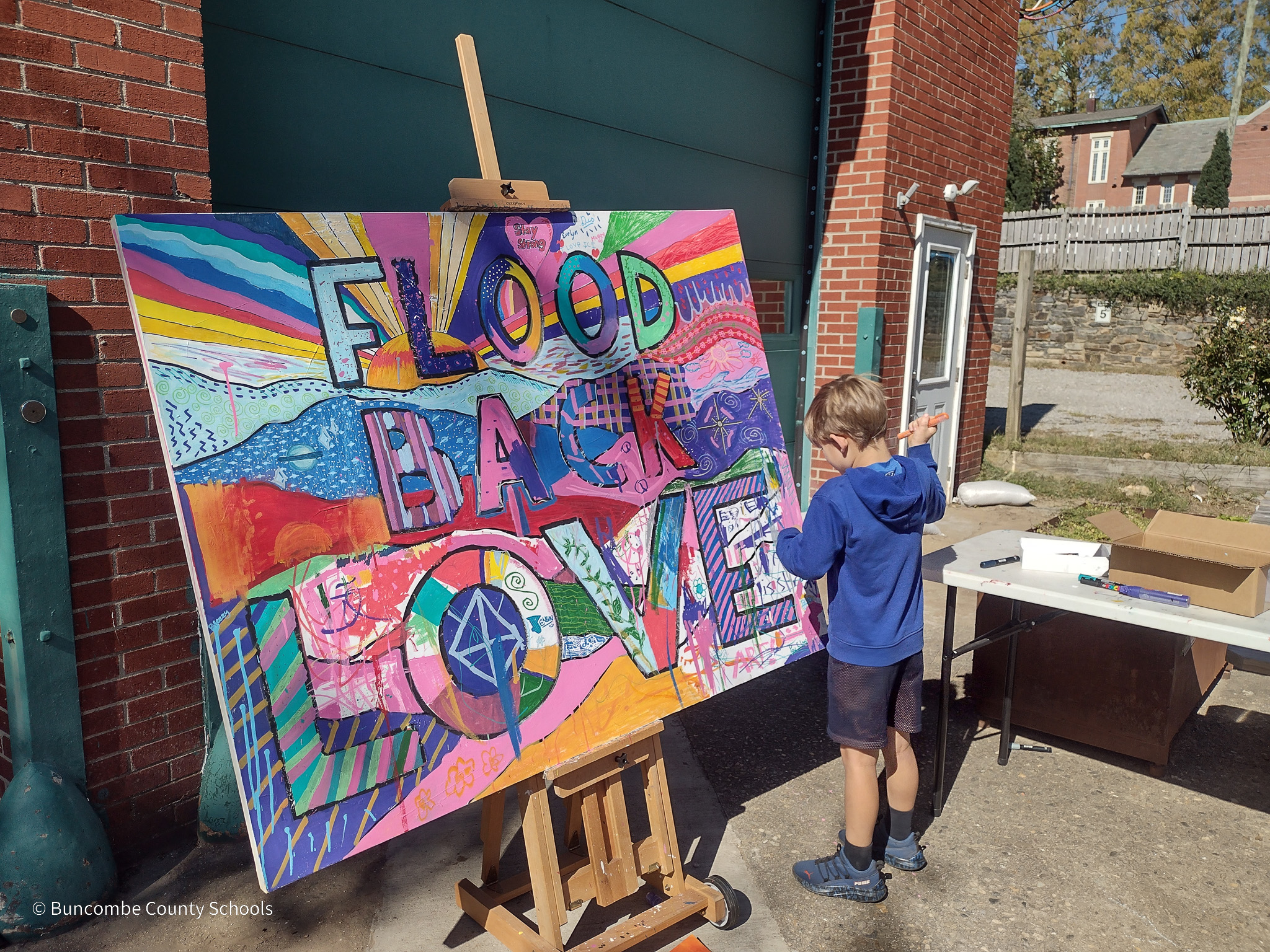 Student working on "flood back love mural 