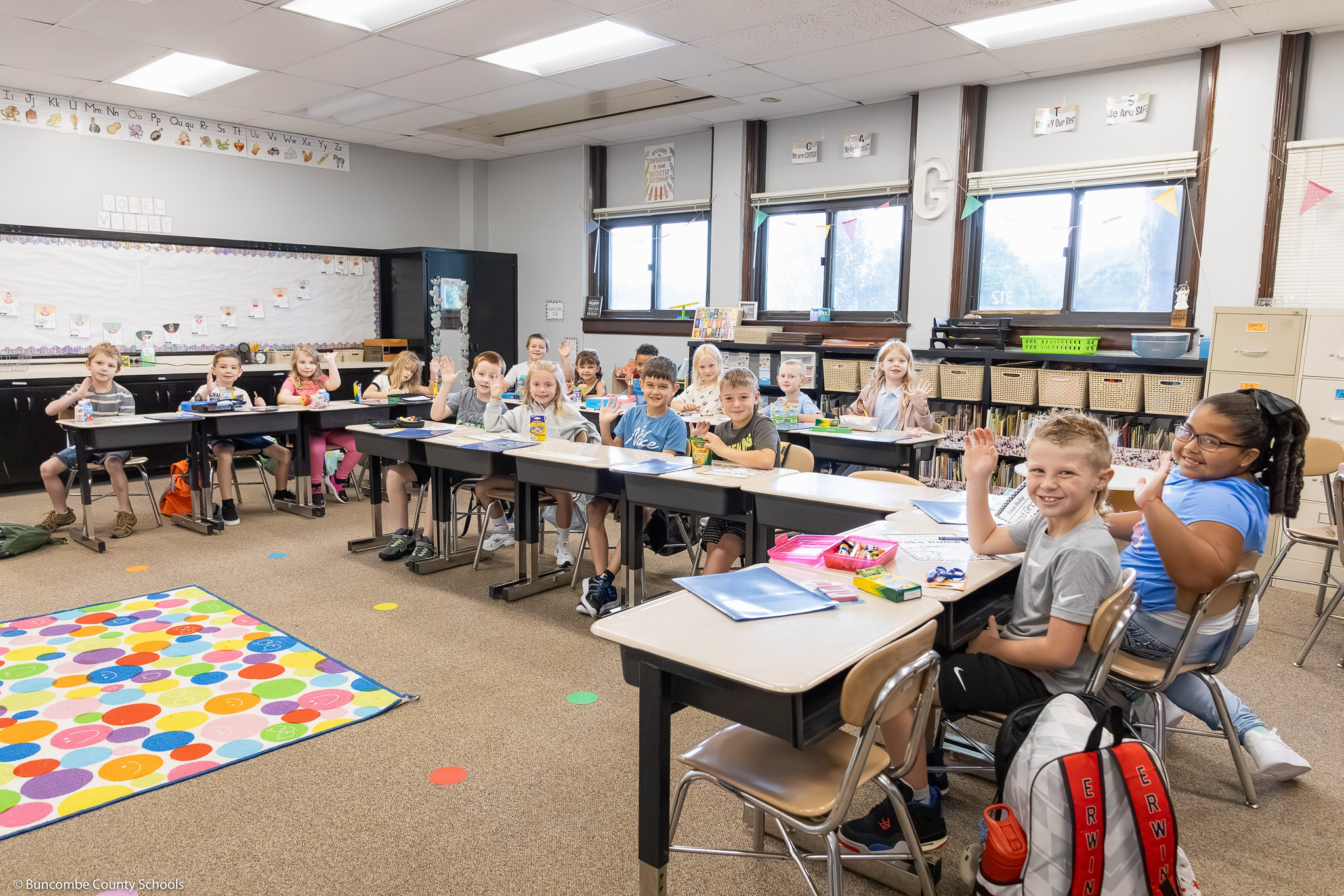 A classroom of students at Leicester Elementary smiling at the camera. 