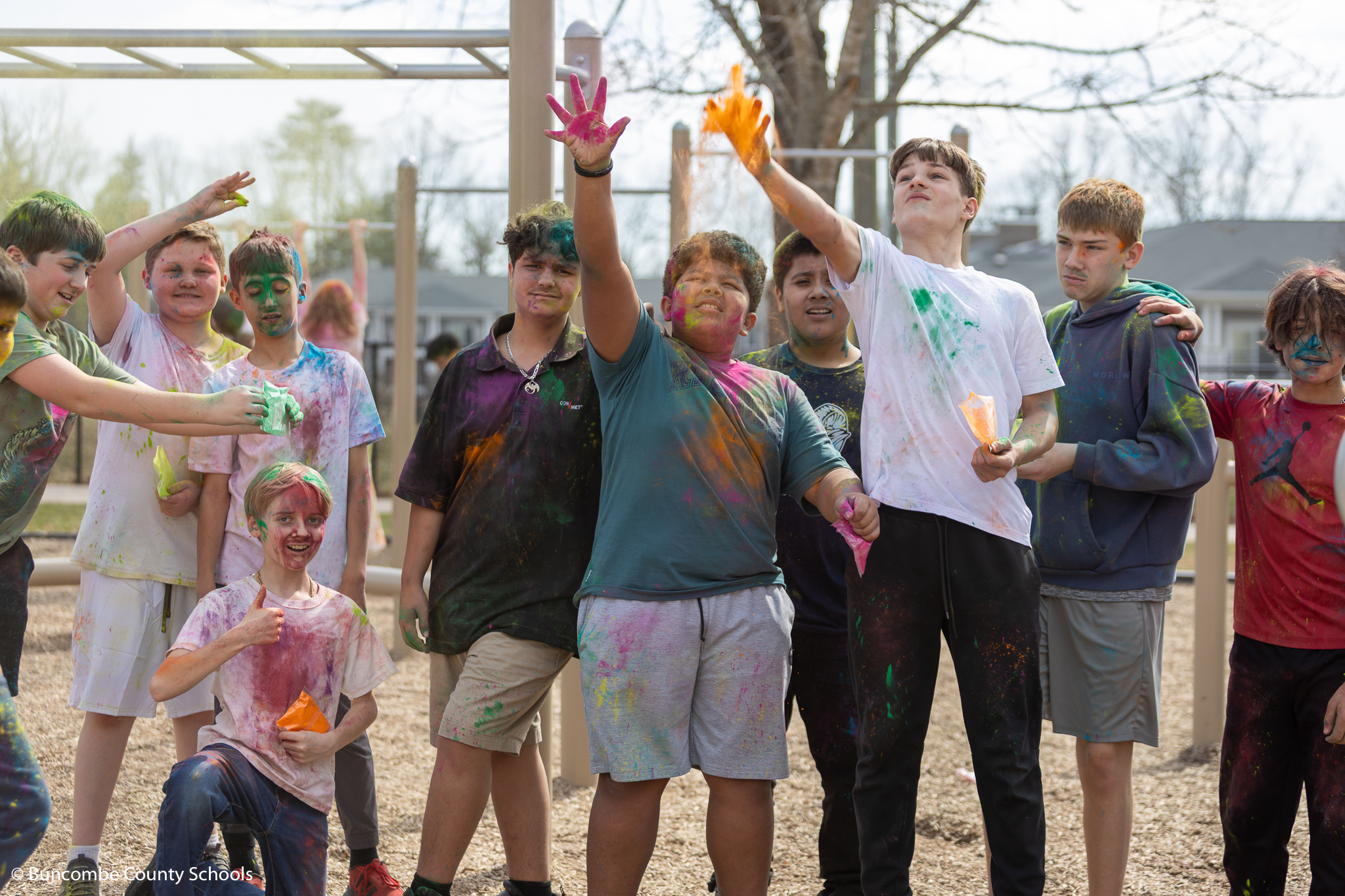 Group of students throwing colored powder in the air. 