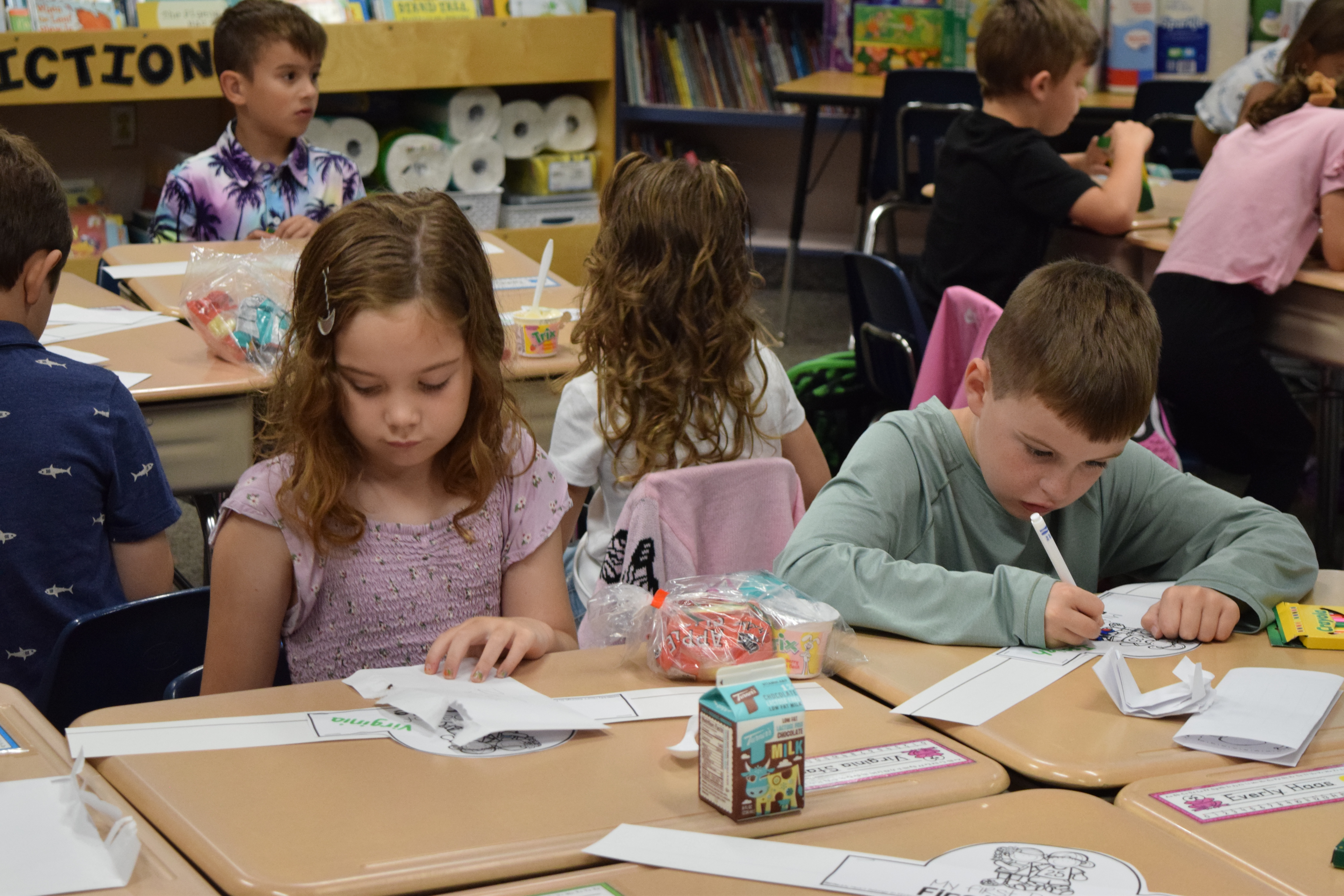 Elementary boy and girl working at desk
