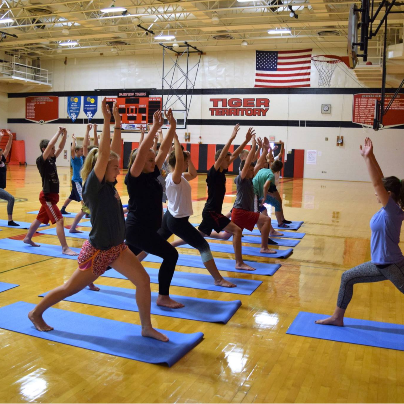 Students practicing yoga on the newly purchased matts