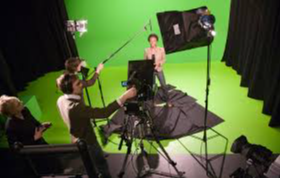 Students recording a video with a green screen