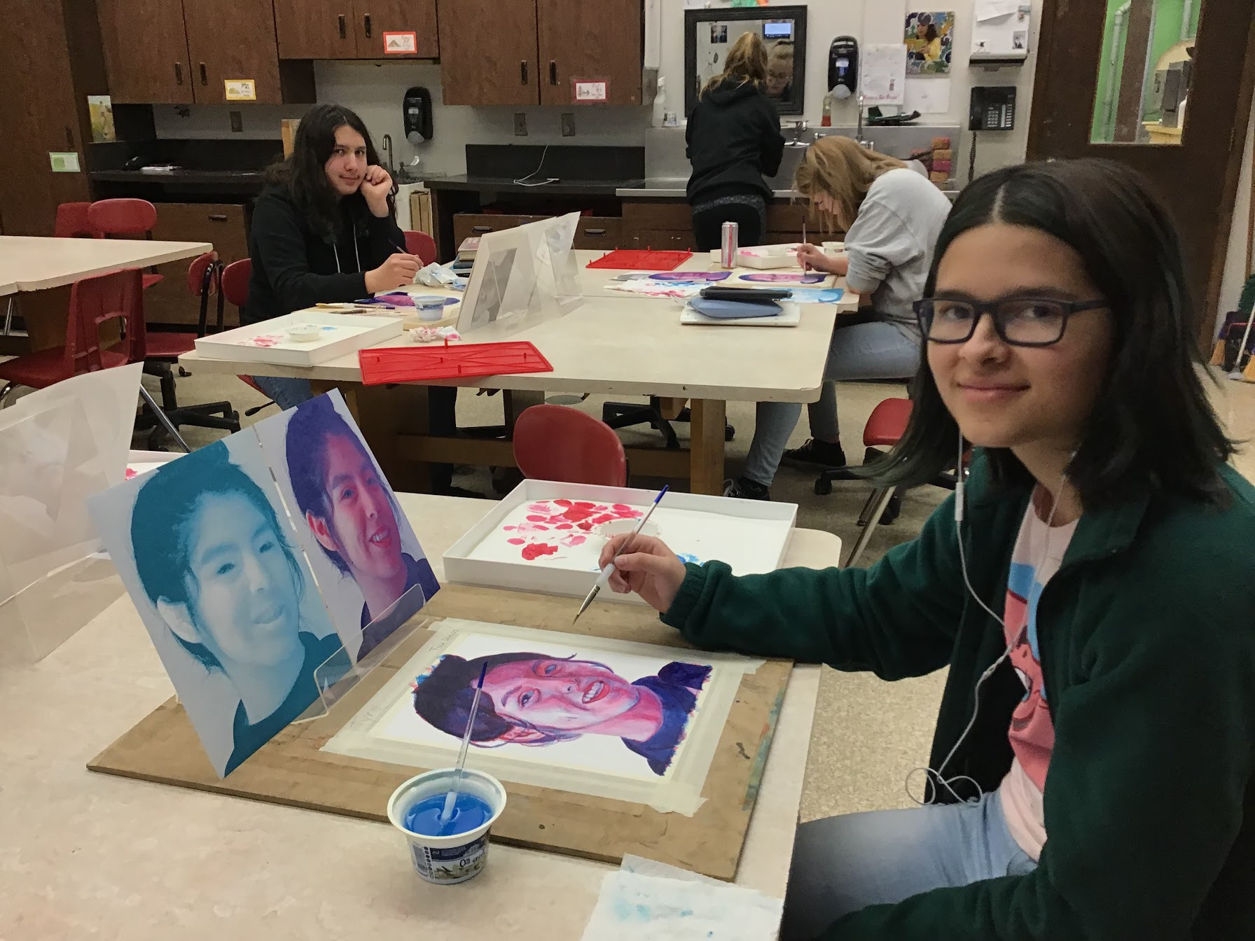 High school student painting a portrait