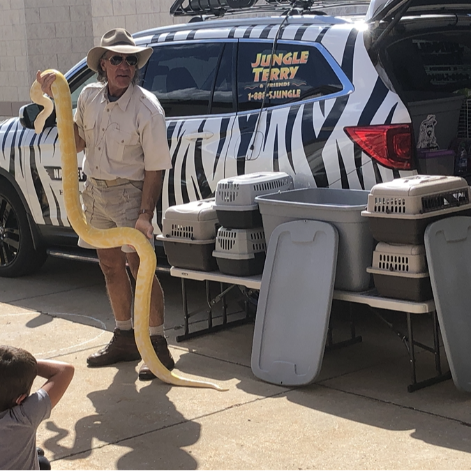 Jungle Terry holding a large yellow snake for Elementary students