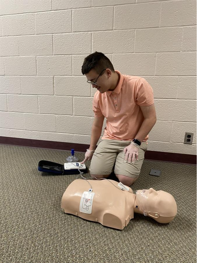 Middle school student using a AED trainer device