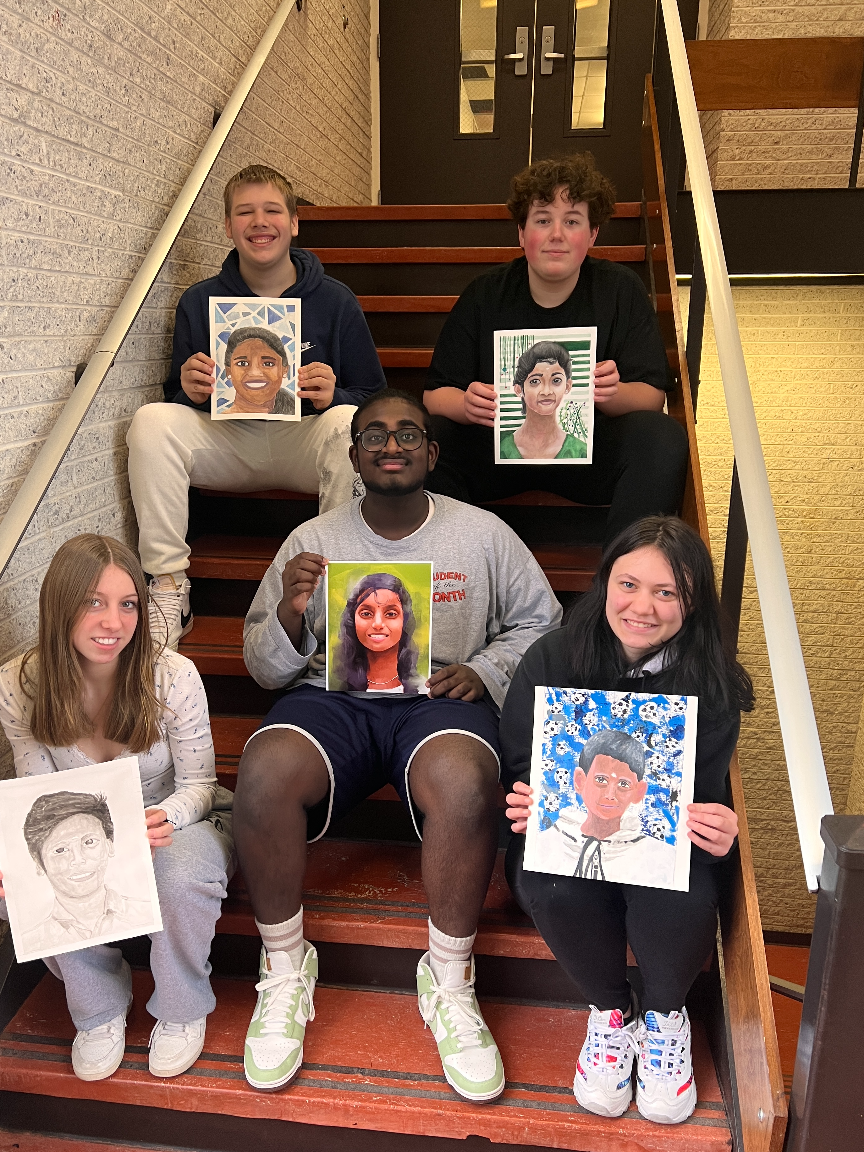 Memory Project Art Students  holding painted portraits