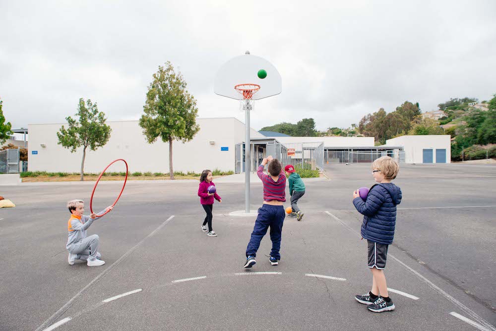 children playing on playground with basketball hoop