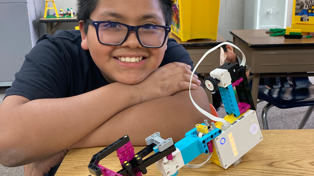 Student showing off completed Lego robot