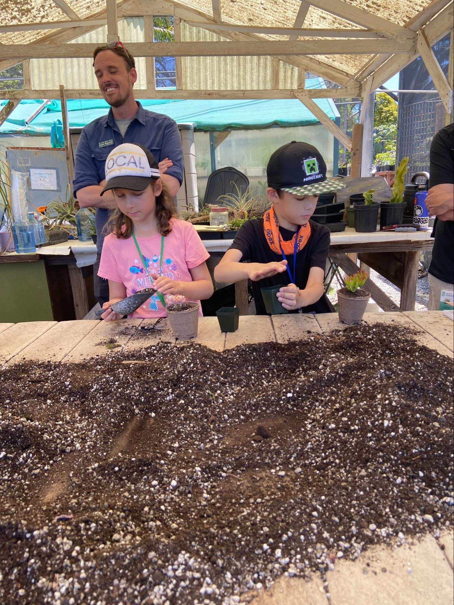 Summer camp students learning about soil and planting.