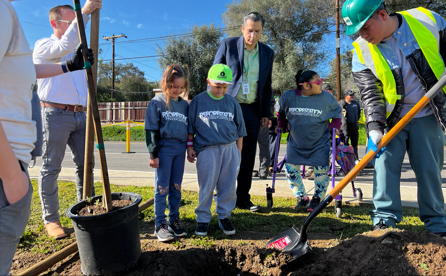 Tree planting at Rock Springs Elementary with students watching the workers shovel dirt.
