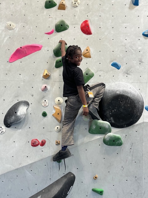 boy climbing a wall at the rock climbing gym