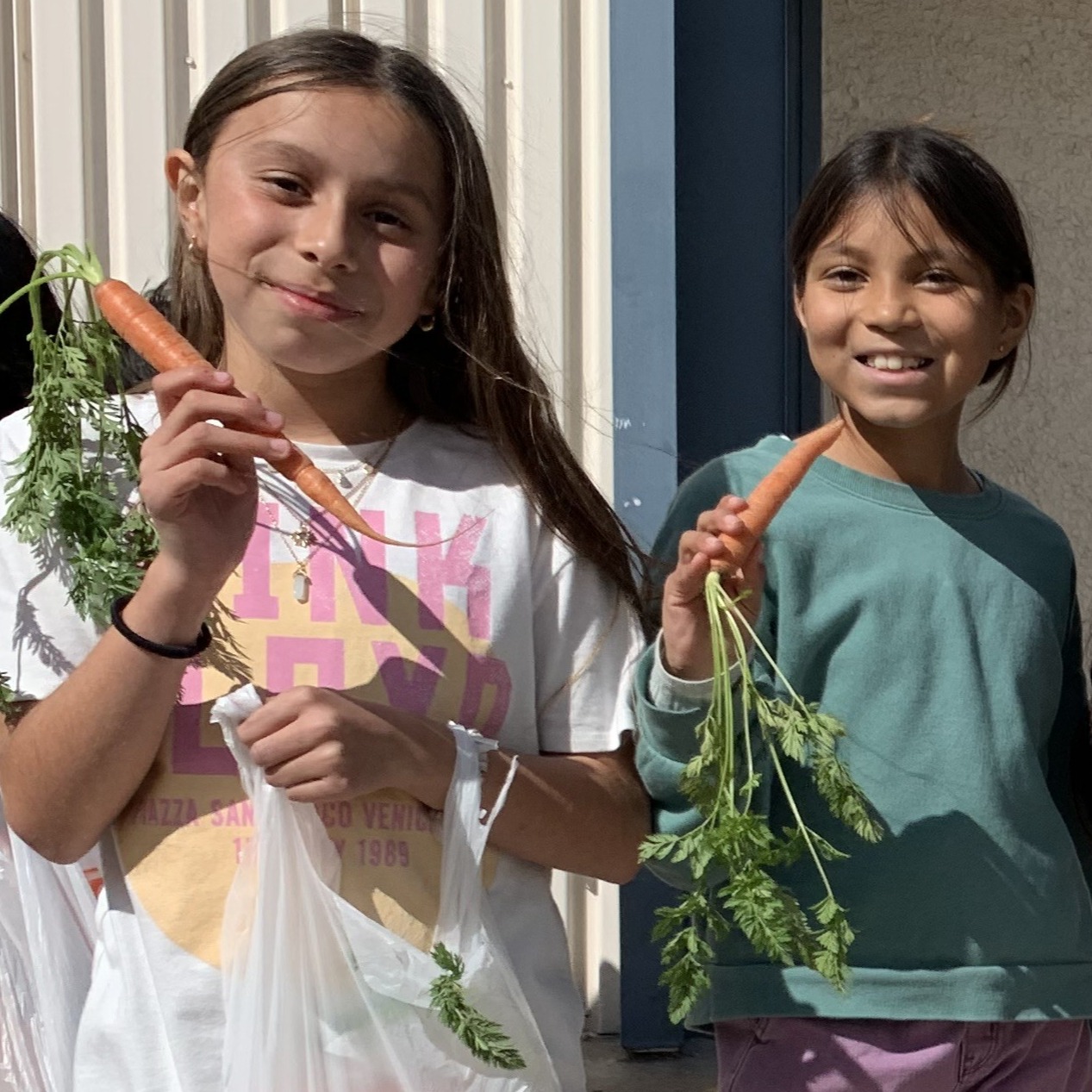 Two  students holding carrots