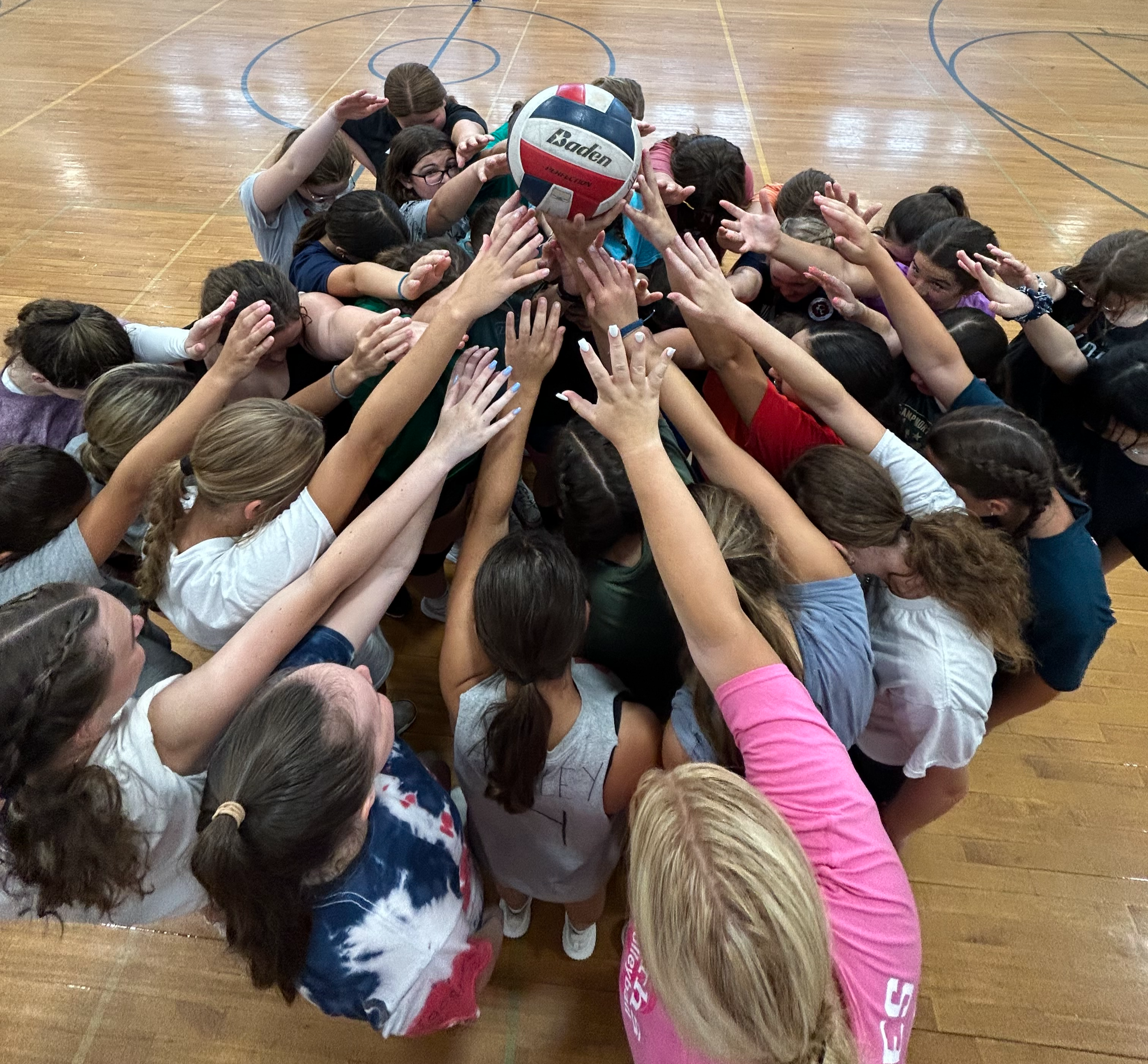 image of volleyball campers reaching for the volleyball