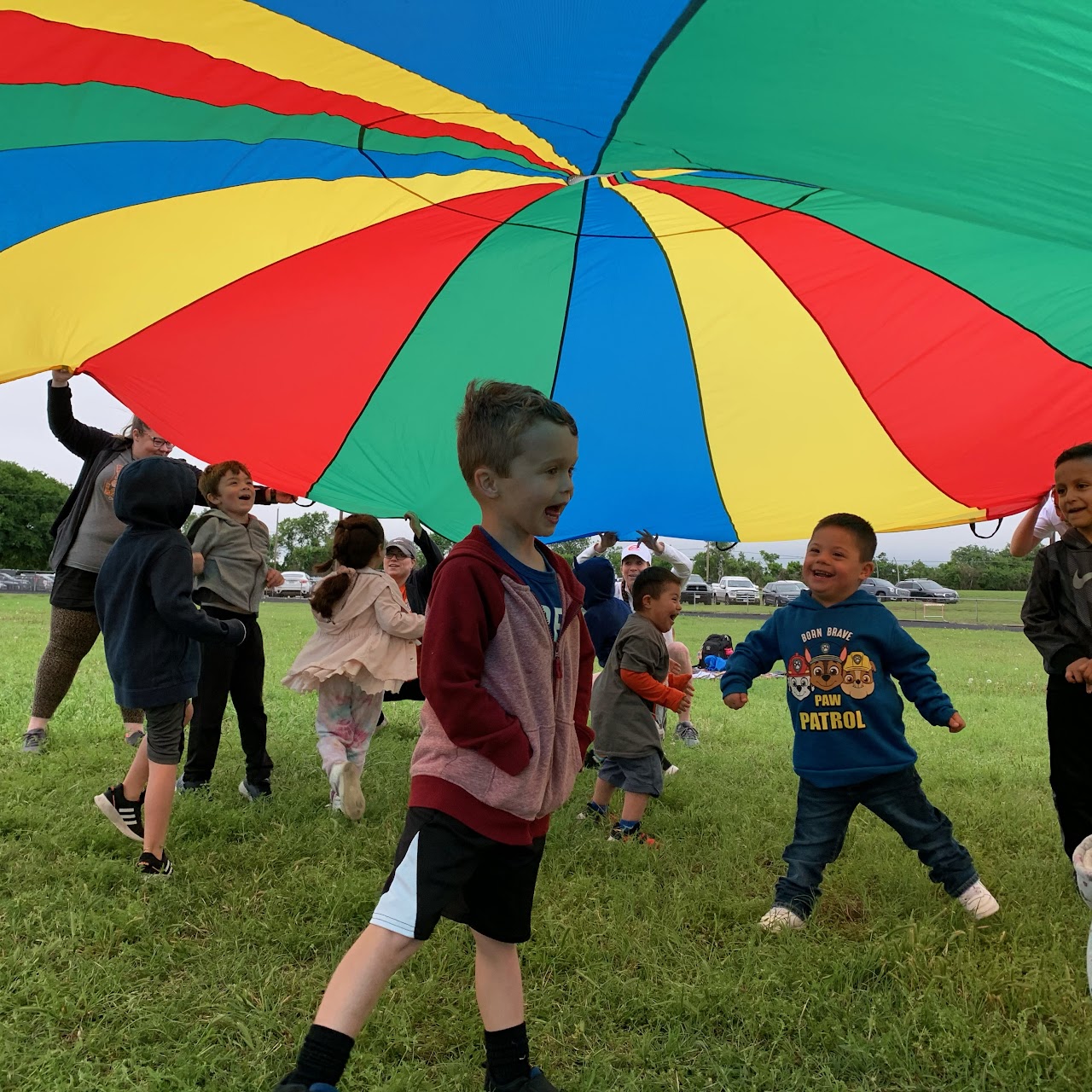 Kids under a colorful umbrella