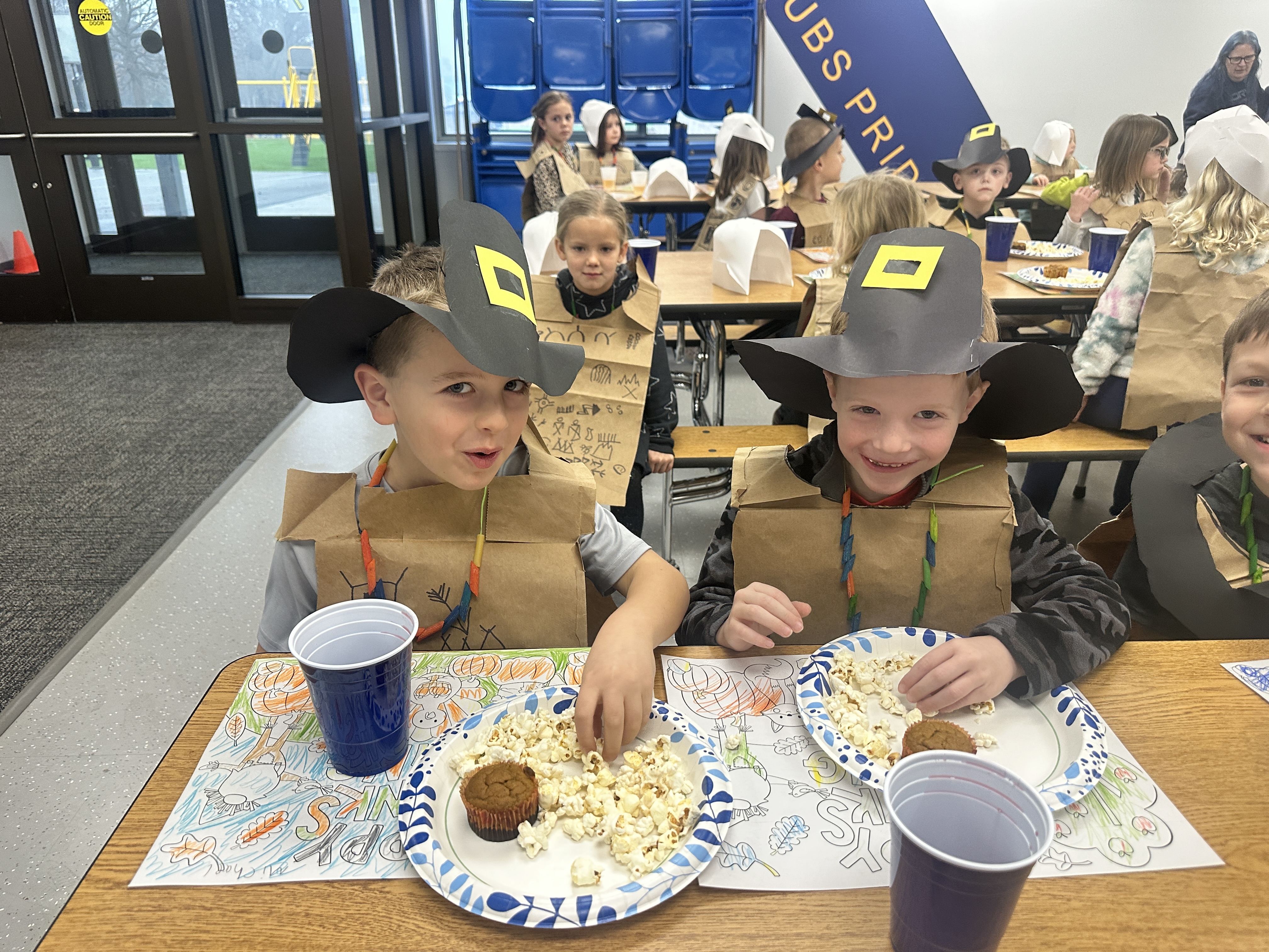 students dressed as pilgrims having a thanksgiving feast