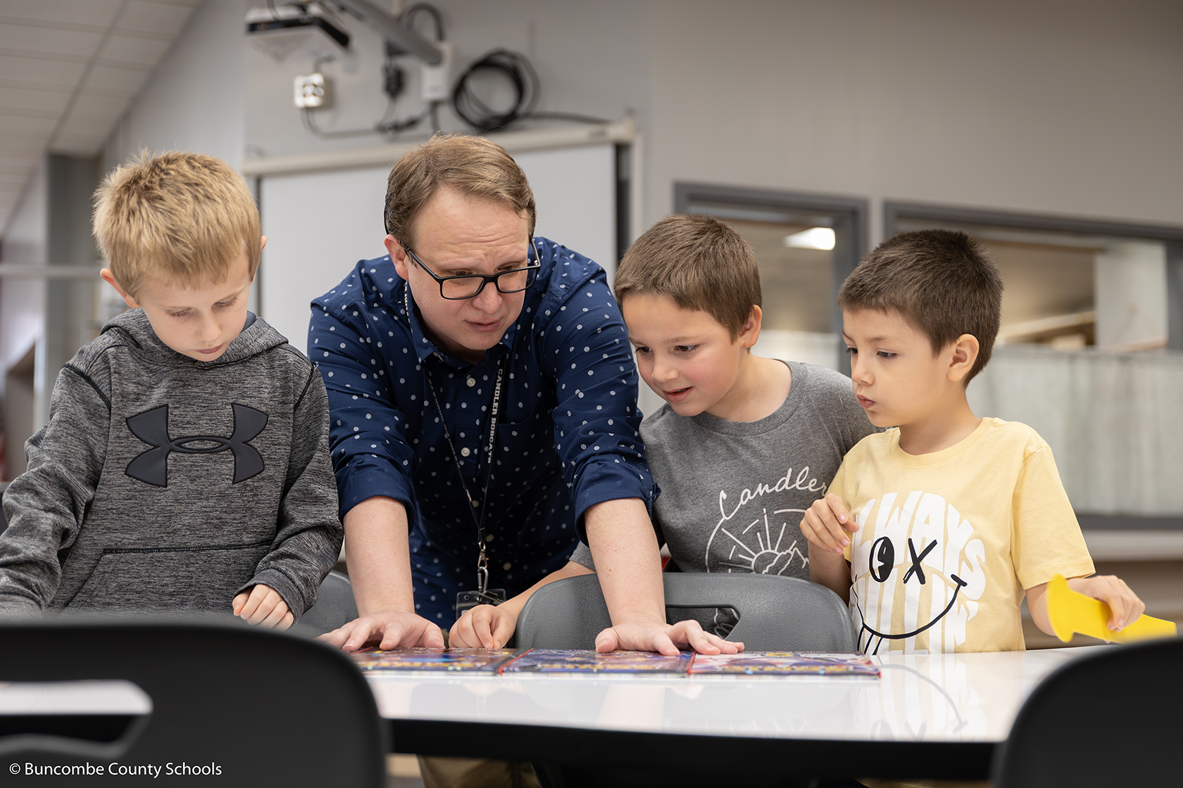 Mr. Henry showing a group of boys the newest Sonic the Hedgehog  books in the Media Center. 