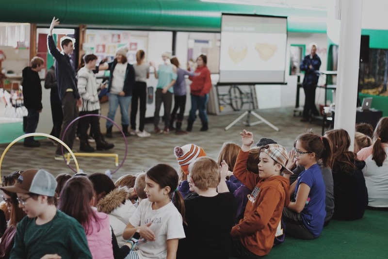 photo of students sitting in line on the ground